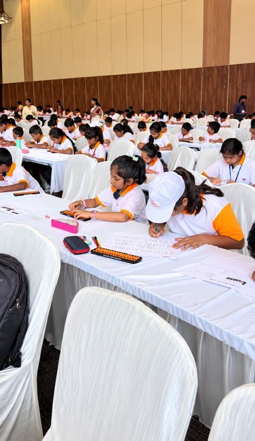 Girls in Mastermind Abacus uniforms solving mental maths competition papers with their abacus