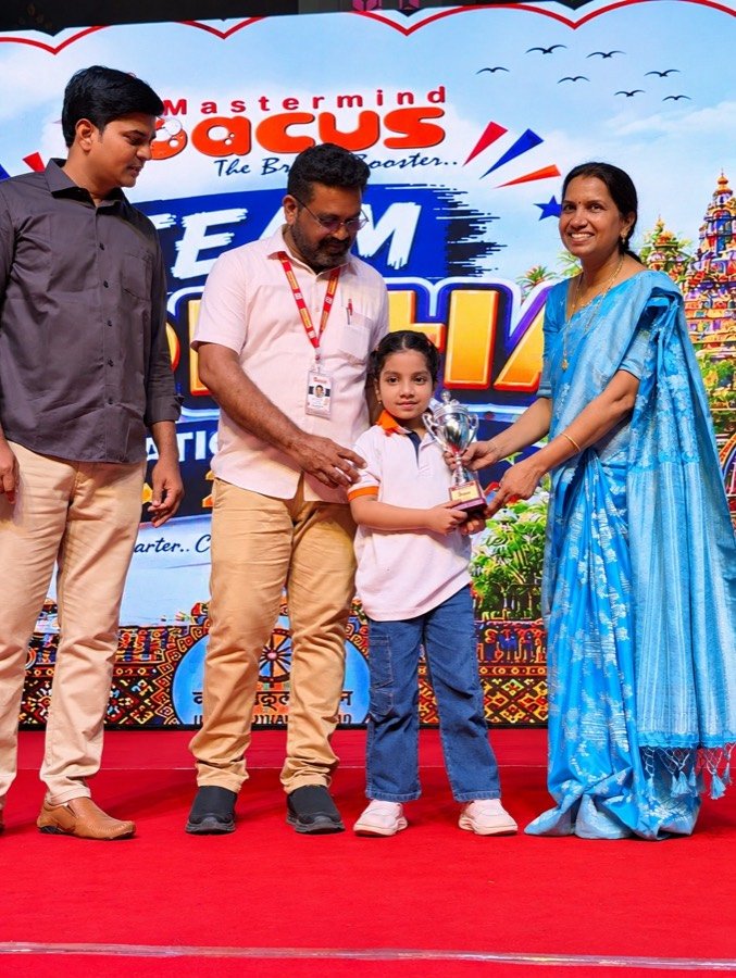 Young Mastermind Abacus student receiving a trophy on stage at a Team Odisha award ceremony